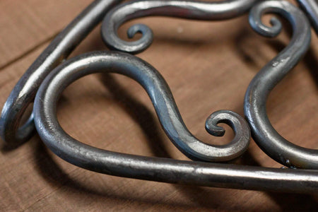 a blacksmith hand forged trivet pot holder by Wicks Forge